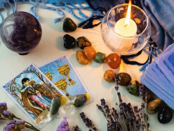 Minsk, Belarus - February 2022: cards of goblets and lovers in tarot divination with candles and sto